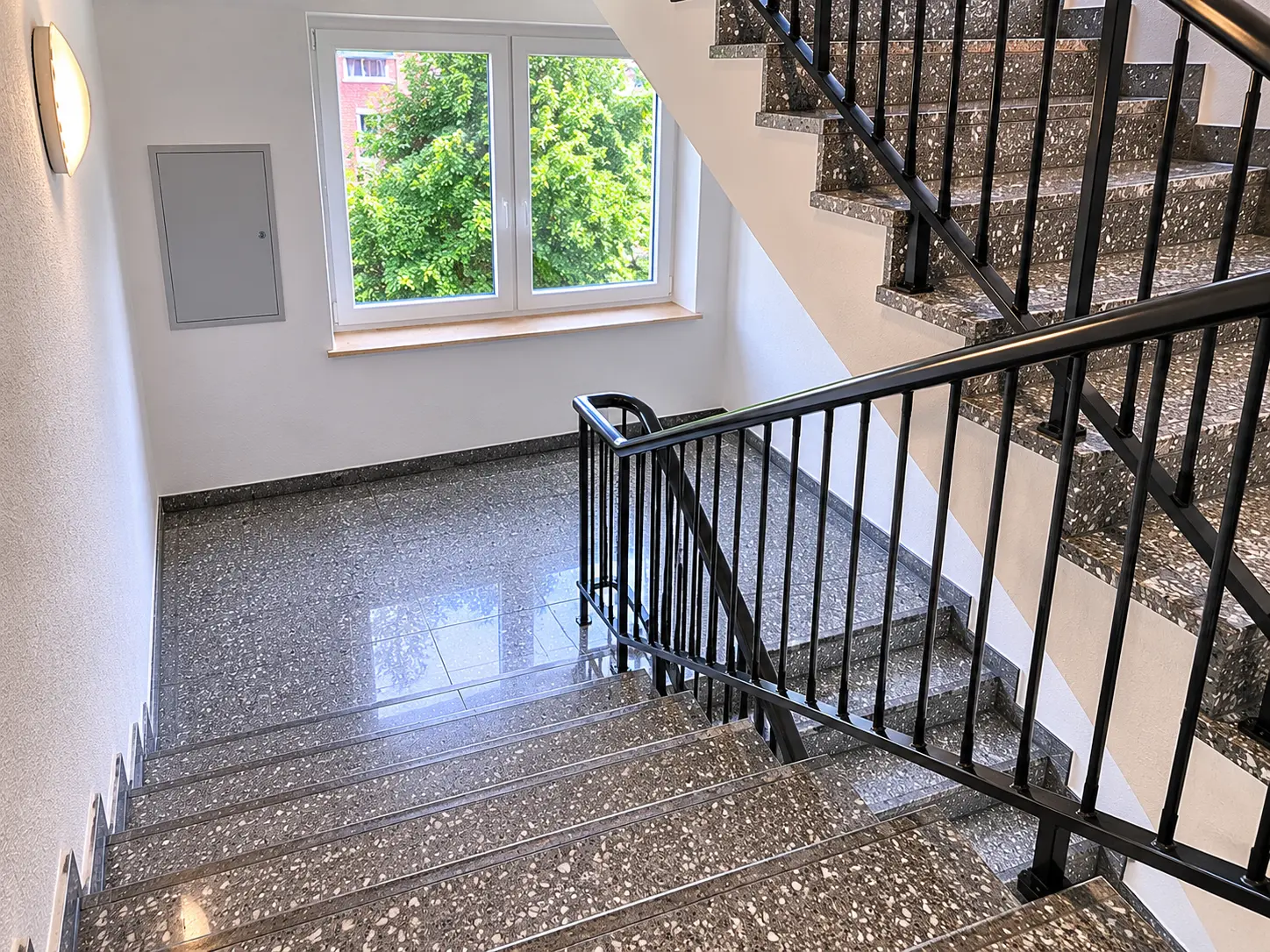 Gepflegtes Treppenhaus mit glänzendem Terrazzoboden nach professioneller Reinigung durch Thein in Bamberg