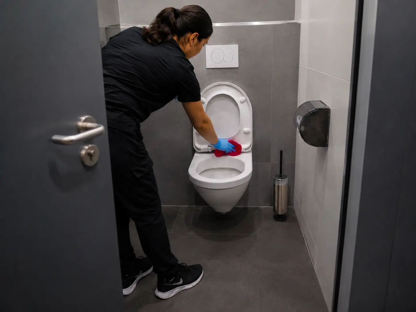 Reinigungskraft reinigt einen Sanitärbereich gründlich und hygienisch in Bamberg