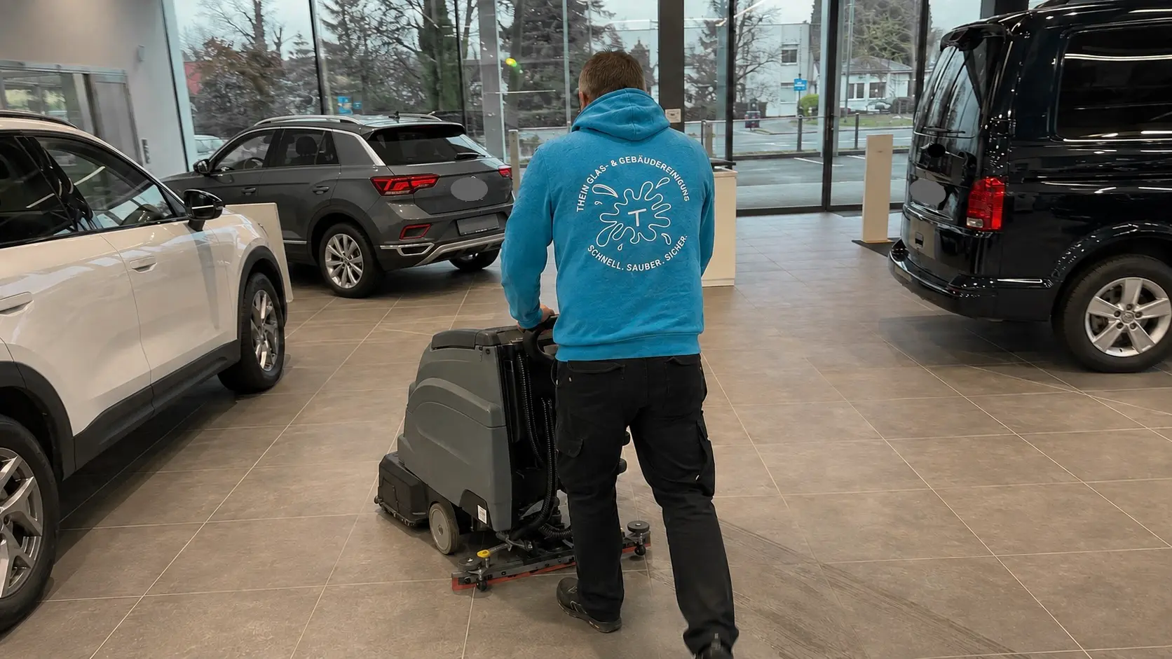 Mitarbeiter reinigt den Showroomboden eines Autohauses in Bamberg