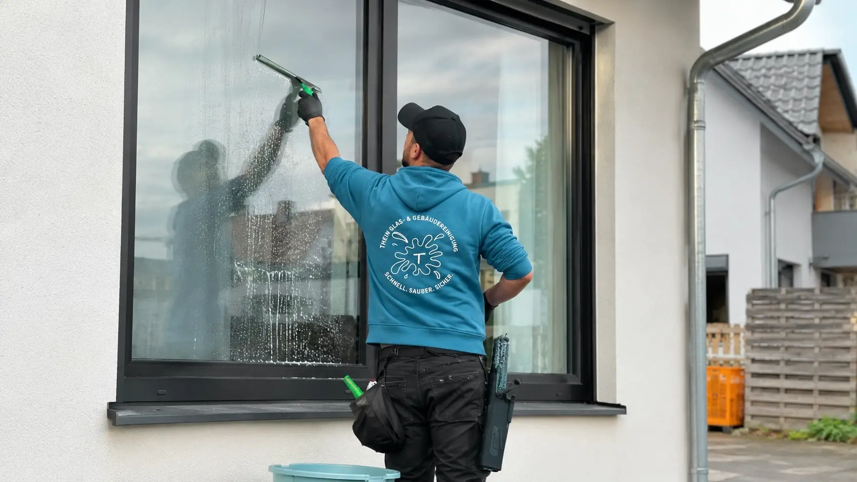 Mitarbeiter zieht eine Glasfront streifenfrei ab in Bamberg